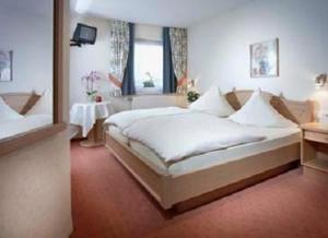 a bedroom with a large white bed and a window at Landhaus Müller in Alken