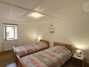 two twin beds in a room with a window at Gîte charmant à la ferme, tout confort, proche de Roanne, idéal pour randonnées et baignades - FR-1-496-220 in Crémeaux