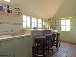 une cuisine avec un évier et une rangée de tabourets de bar dans l'établissement Maison de charme avec piscine chauffée et wifi au cœur du Perche - FR-1-497-186, à Appenai-sous-Bellême