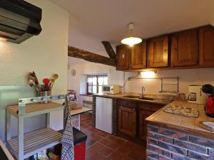 eine Küche mit Holzschränken und einer Arbeitsplatte in der Unterkunft Charmante longère dans le Perche avec jardin et animaux admis - FR-1-497-218 in Bretoncelles + 27 Fotos