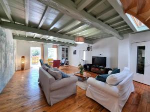 a living room with white furniture and wooden floors at Gîte spacieux 10 pers: Nature, Spa, Confort - FR-1-496-358 in Saint-Denis-sur-Coise