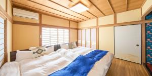 a large white bed in a room with a window at Awaji Kusaka Jungle in Awaji