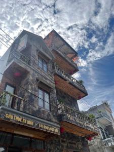 ein hohes Gebäude mit einem Balkon an der Seite in der Unterkunft Miêu Vương Homestay Mèo Vạc in Mèo Vạc
