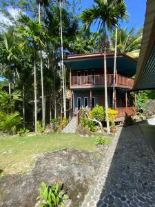 a house with palm trees in front of it at BESTUBA COTTAGE at PULAU TUBA, LANGKAWI in Pulau Selang Besar