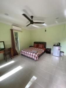 a bedroom with a bed and a ceiling fan at BESTUBA COTTAGE at PULAU TUBA, LANGKAWI in Pulau Selang Besar