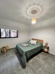 ein Schlafzimmer mit einem grünen Bett und einer Decke in der Unterkunft Complejo Entre Parras in San Rafael