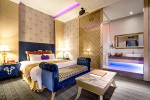 a bedroom with a bed and a couch and a tub at Norway Forest SPA Motel in Xindian