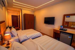 una camera d'albergo con due letti e una televisione di THree PYramiDs & SPhinX HoTeL a Il Cairo