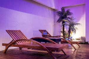 two chairs and a table in a room with a palm tree at Norway Forest SPA Motel in Xindian