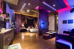 a hotel room with a bedroom with a bed and a tv at Norway Forest SPA Motel in Xindian