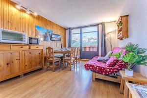 a living room with a table and a dining room at Modern 3BR Duplex - Val Thorens Centre, Parking & Panoramic Views in Val Thorens