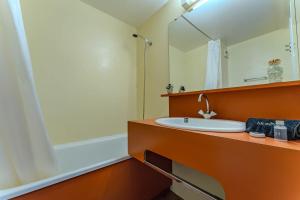 a bathroom with a sink and a mirror and a tub at Modern 3BR Duplex - Val Thorens Centre, Parking & Panoramic Views in Val Thorens