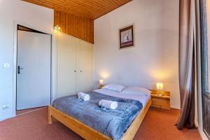 a bedroom with a bed with two pillows on it at Modern 3BR Duplex - Val Thorens Centre, Parking & Panoramic Views in Val Thorens