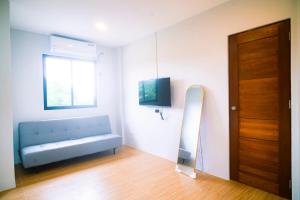 ein Zimmer mit einer blauen Bank und einem Fernseher in der Unterkunft The Grounds Hotel in San Jose del Monte
