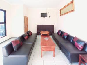 a living room with a couch and a table at RedDoorz near BNS 3 Kota Wisata Batu in Malang