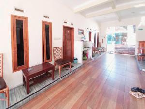a living room with wooden floors and a table and chairs at RedDoorz near BNS 3 Kota Wisata Batu in Malang