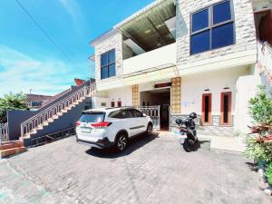 a white car parked in front of a house at RedDoorz near BNS 3 Kota Wisata Batu in Malang