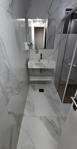 un bagno bianco con lavandino e specchio di Agradável flat-Águas de Lindóia ad Águas de Lindóia