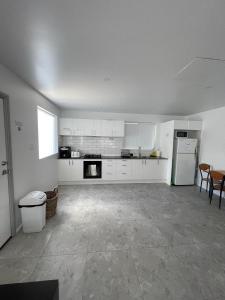 an empty kitchen with white cabinets and a table at CozyHomes Woolloongabba B&B in Brisbane +12 photos