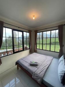 a bed in a room with large windows at Ikiikahomestay in Probolinggo +20 photos