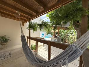 a hammock hanging from a porch with a table and a table at Casita Almendro-Apartment With Heated Pool in San Germán