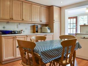 a kitchen with a table with chairs and a table and a table and chairsktop at The Cottage in Blakeney