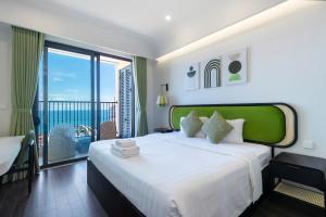 a bedroom with a large bed and a balcony at Skyline Hillside Apartment Phu Quoc in Phú Quốc +188 photos