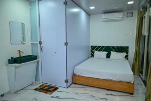 a small bedroom with a bed and a glass wall at Bellajooz Lake Resort in Takwa Budrukh