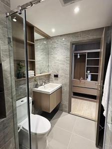 a bathroom with a toilet and a sink and a shower at Tierra Residences Bangkok in Bangkok