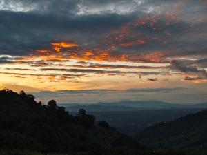 a sunset in the mountains with a cloudy sky at Típica in Pijao