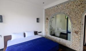 a bedroom with a bed and a large mirror at Hakuna Matata Arugambay in Arugam Bay