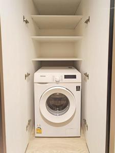 a washer and dryer in a small closet at Tierra Residences Bangkok in Bangkok +36 photos