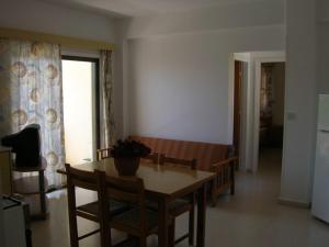 ein Esszimmer mit einem Tisch und Stühlen sowie eine Küche in der Unterkunft Marios Apartments in Perivolia