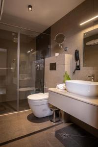 a bathroom with a toilet and a sink and a shower at Winterfeel Luxury Resort Kodaikanal in Kodaikānāl