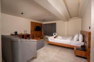 a large bedroom with a bed and a couch at Winterfeel Luxury Resort Kodaikanal in Kodaikānāl