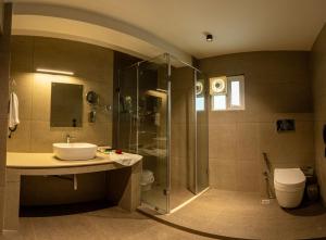 a bathroom with a shower and a sink and a toilet at Winterfeel Luxury Resort Kodaikanal in Kodaikānāl +37 photos