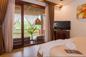 ein Schlafzimmer mit einem Bett und einem großen Fenster in der Unterkunft Hoi An Eco Lodge & Spa in Hoi An