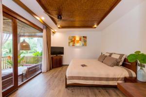 ein Schlafzimmer mit einem Bett und einem Balkon in der Unterkunft Hoi An Eco Lodge & Spa in Hoi An