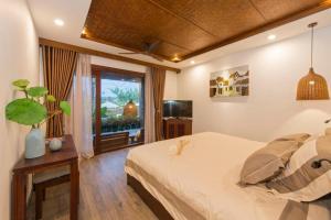ein Schlafzimmer mit großem Bett und Fenster in der Unterkunft Hoi An Eco Lodge & Spa in Hoi An