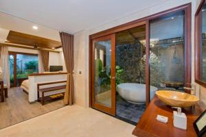 ein Bad mit einer Badewanne und einem Waschbecken sowie ein Schlafzimmer in der Unterkunft Hoi An Eco Lodge & Spa in Hoi An