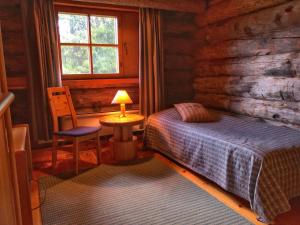 a bedroom with a bed in a log cabin at Santa's Villa Borealis in Luosto