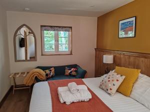 a bedroom with a bed and a chair and a mirror at Hayne Barn Estate - Luxury Lodges with private hot-tubs- The studio-loft is without hot-tub in Hythe