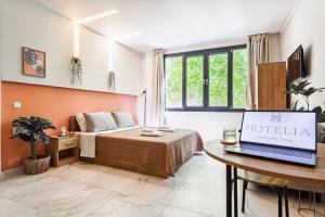 a hotel room with a bed and a laptop on a table at AEONS - Hotelia Hospitality Group in Thessaloniki
