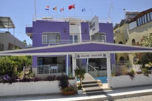 a purple building with a porch and stairs in front at Dalyan Terrace Hotel in Dalyan