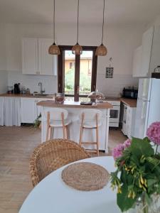 une cuisine avec des armoires blanches et une table avec des chaises dans l'établissement Villa Biancaluna, à San Felice del Benaco 40 autres photos