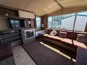 a living room with a couch and a flat screen tv at Spacious 8 Berth Caravan At Dovercourt Holiday Park, Essex Ref 44202K in Great Oakley
