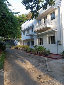 a white house with a lot of plants in front of it at Fern Hill Cottage Kandy in Kandy +6 photos