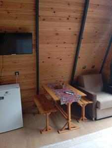 a room with a table and a couch and a tv at La Vica Bungalow in Rize