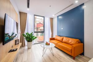 a living room with an orange couch and a table at Myrcella Urban Apartment in Hanoi