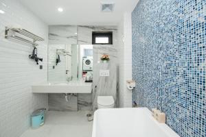 a bathroom with a tub and a sink and a toilet at Myrcella Urban Apartment in Hanoi